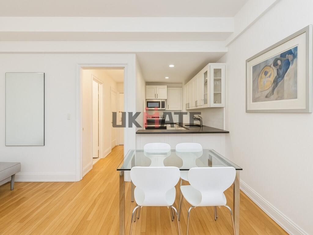 Bright and modern kitchen featuring white cabin...