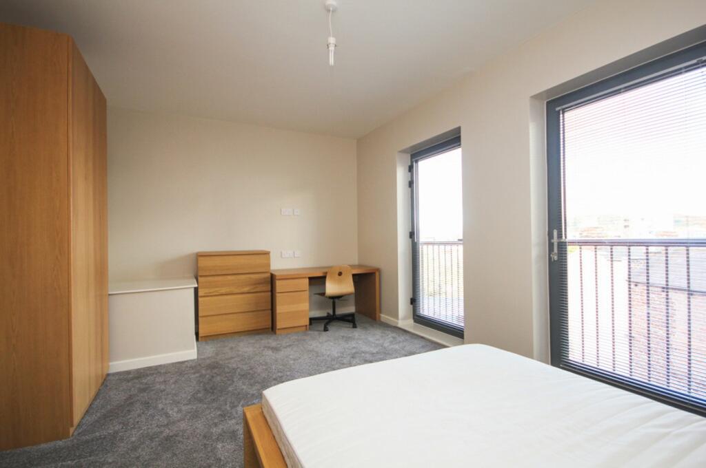 A bright and spacious double bedroom with moder...