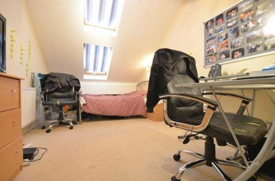 A cozy, well-lit single bedroom featuring a com...