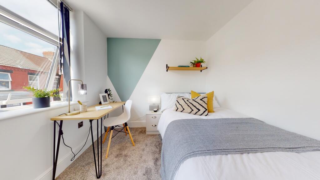 A bright and stylish double bedroom featuring a...