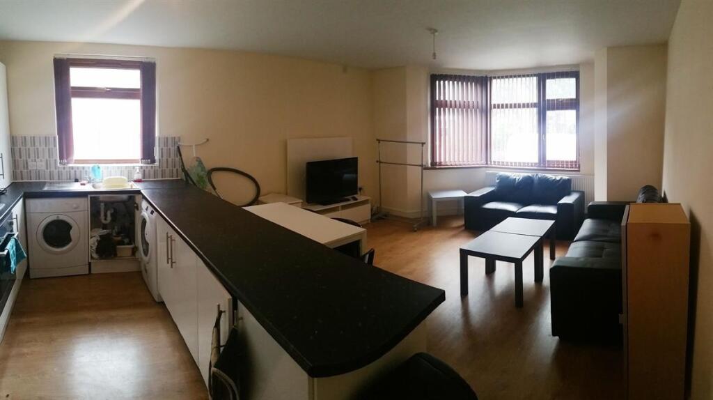 Spacious open-plan living area with large windo...