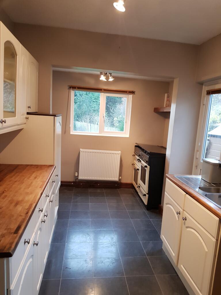 A spacious and bright kitchen featuring ample c...