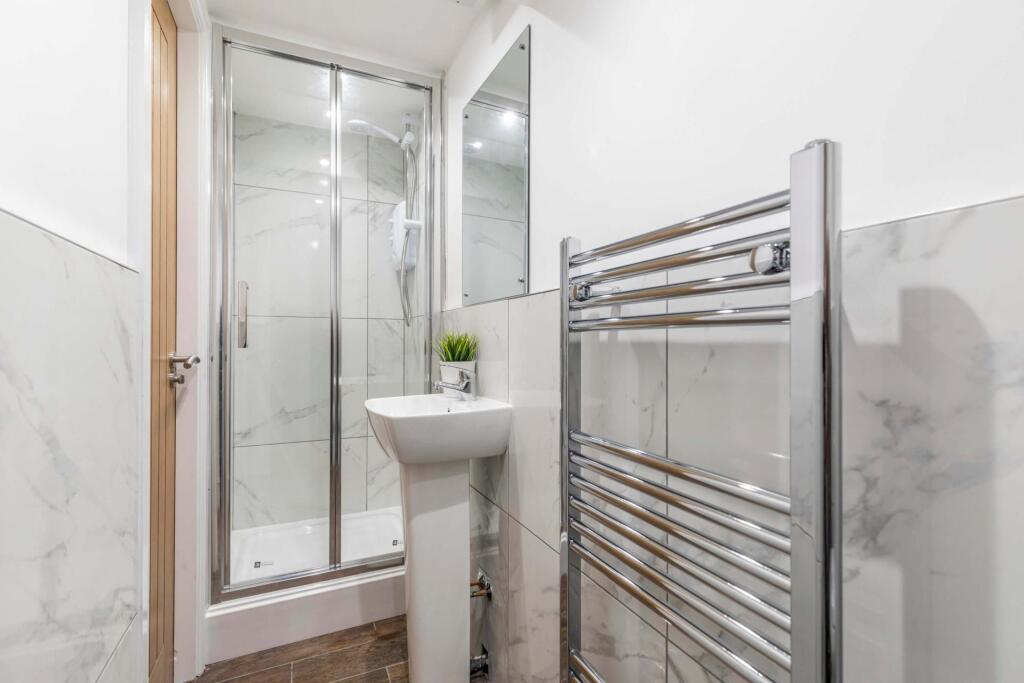 Modern bathroom with a glass-enclosed shower, p...