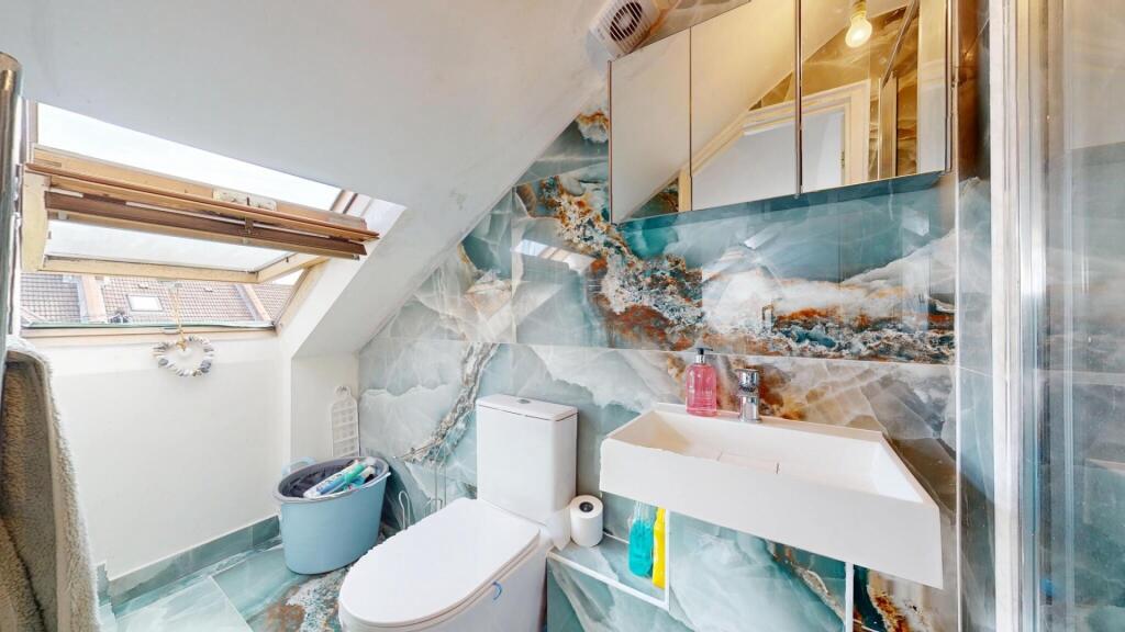 A modern bathroom suite featuring a large skyli...