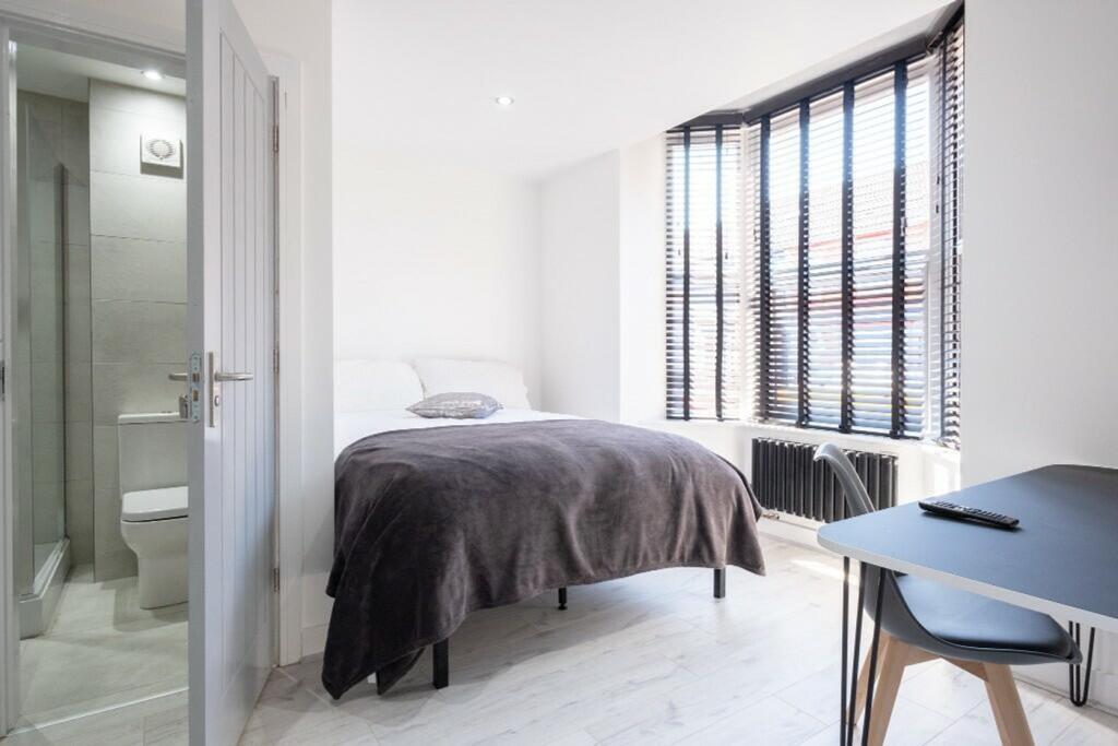 This spacious double bedroom features large win...