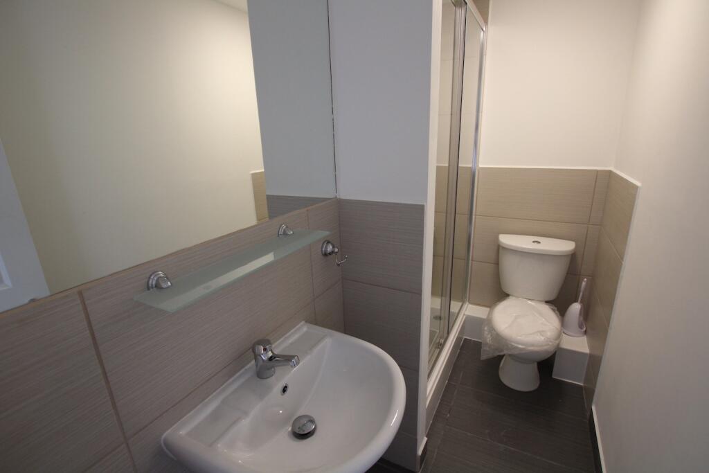A modern, clean bathroom featuring a toilet and...