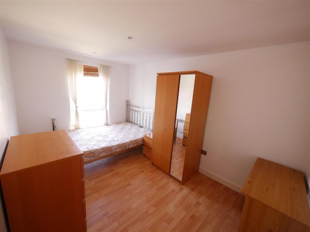 Bright double bedroom featuring a large window ...