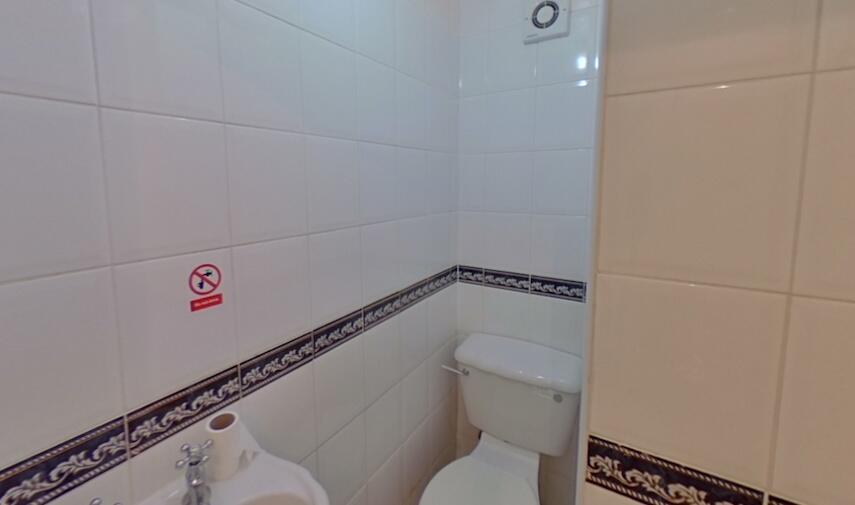 A clean and functional single toilet room featu...
