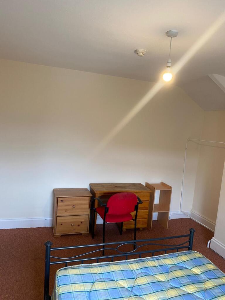 A simple single bedroom featuring a metal frame...