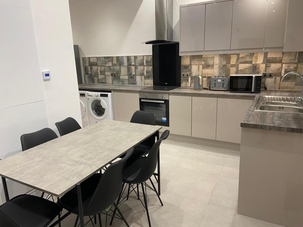 Modern open-plan kitchen with integrated applia...