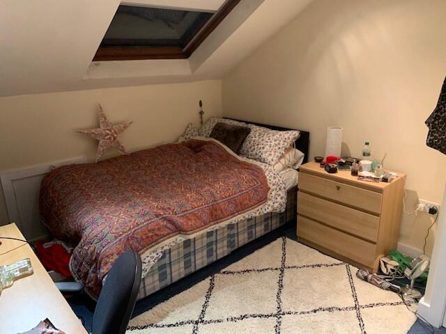 A cozy double bedroom featuring a bed with patt...