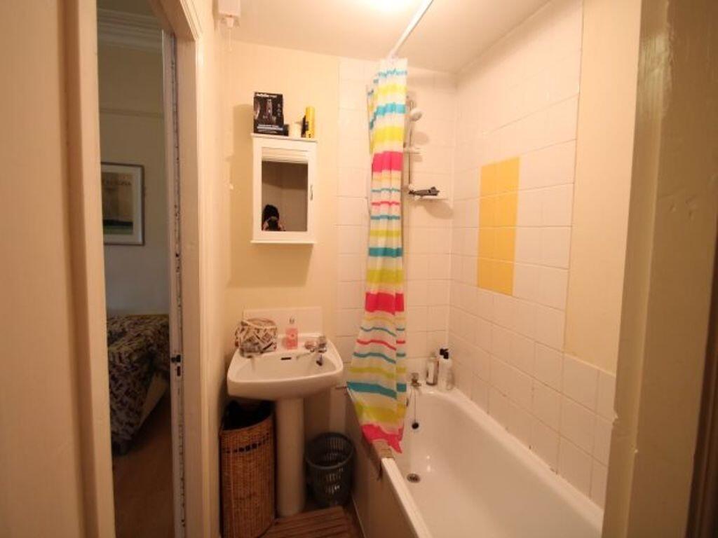 Neat, functional bathroom with a built-in bath,...