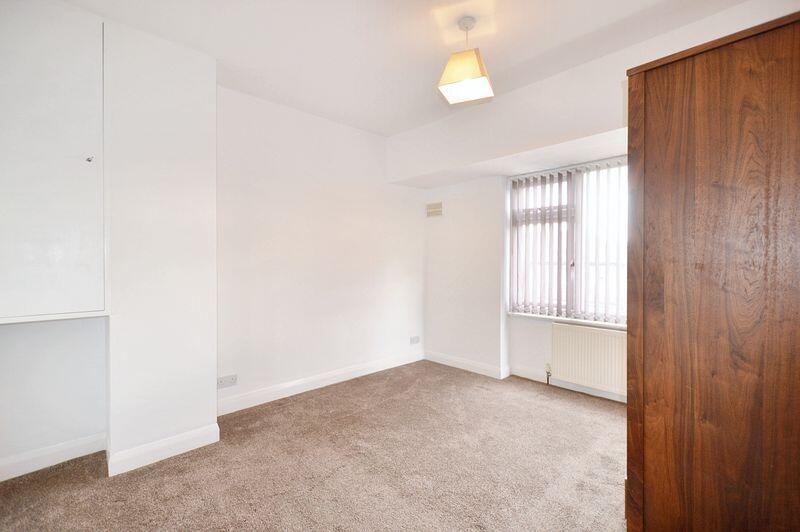 A bright double bedroom featuring neutral tones...