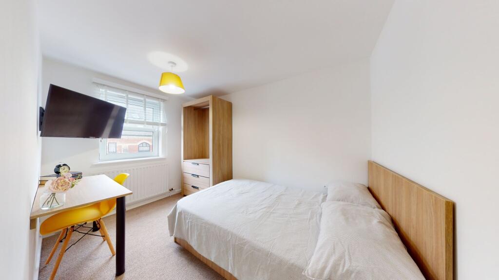 Bright, cozy bedroom featuring a comfortable do...