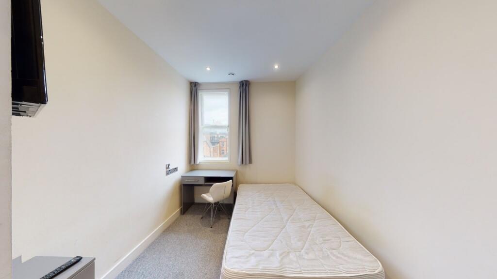 A neat and simple single bedroom featuring a co...