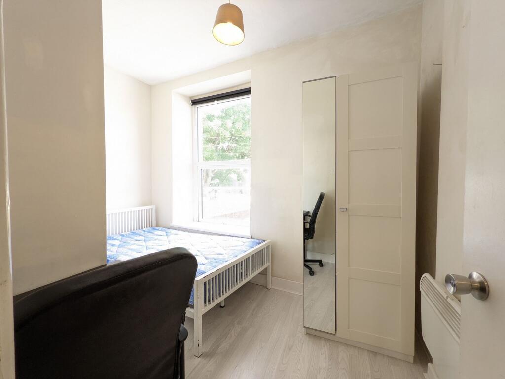 Bright, simply furnished bedroom with a large f...