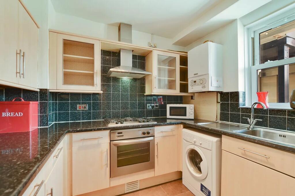 Modern kitchen with light wood cabinets, black ...
