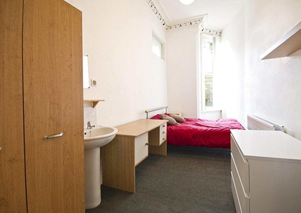 A bright and tidy double bedroom featuring mode...