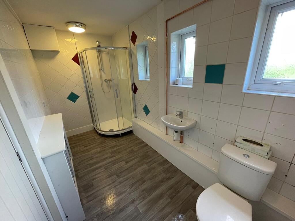 A spacious, well-lit bathroom featuring a moder...