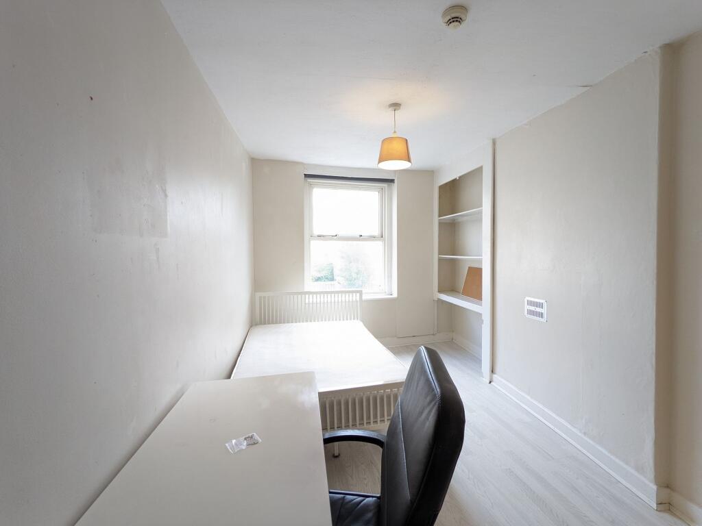 Bright, simply furnished bedroom with a single ...