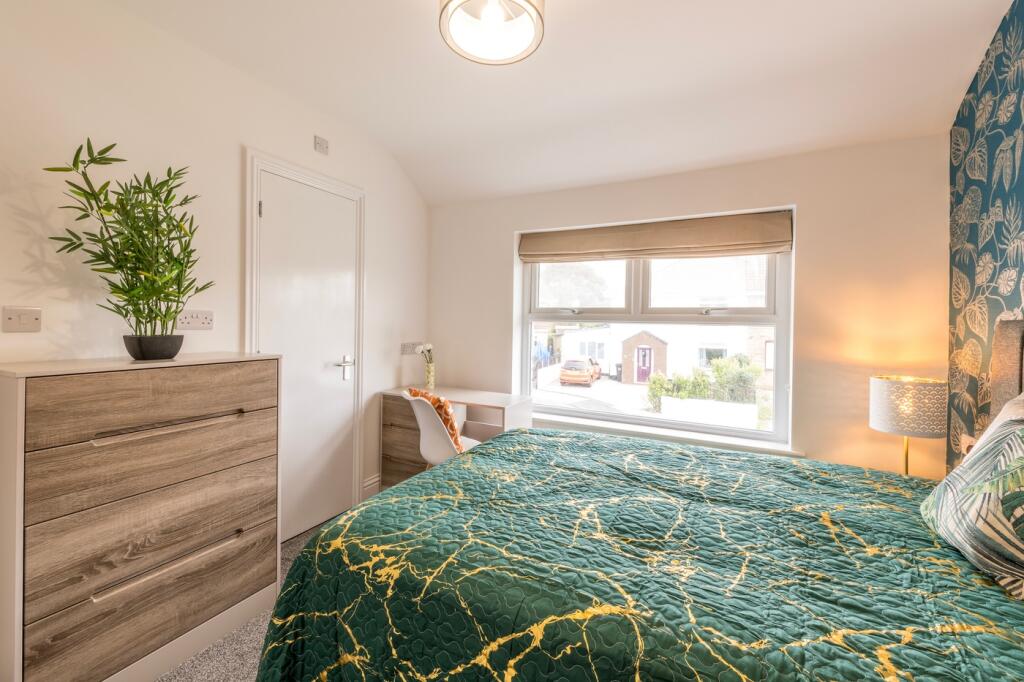 A bright and inviting double bedroom with moder...