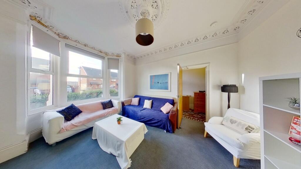 Bright and airy living room featuring large win...