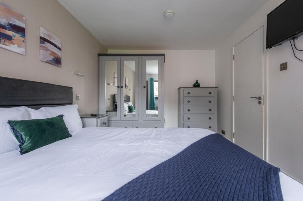 A stylish double bedroom featuring a comfortabl...