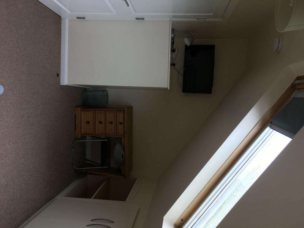 A cozy single bedroom featuring a large window ...