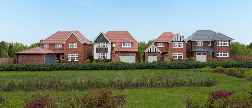 A row of modern detached houses with brick exteriors and pitched roofs, surrounded by greenery and a