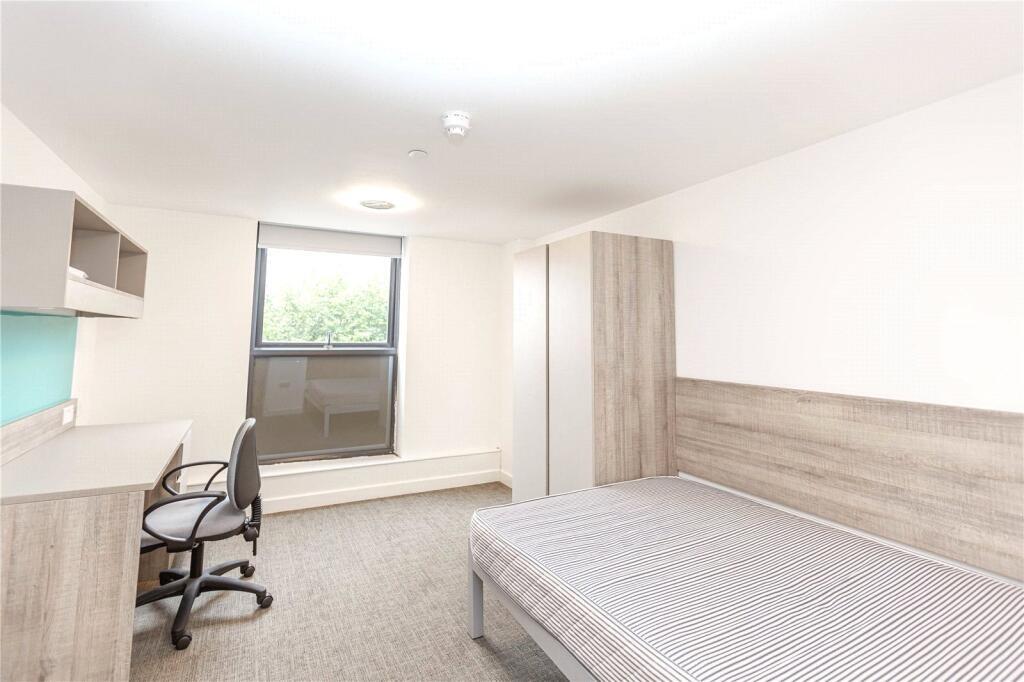 A bright and tidy single bedroom featuring a co...