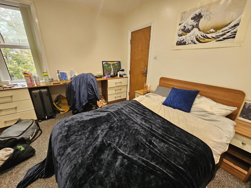 A cozy bedroom featuring a double bed with a da...