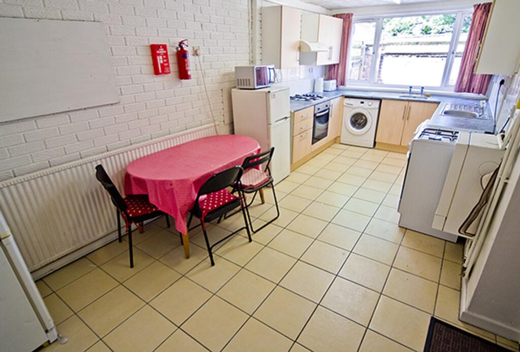 A spacious and bright kitchen area with ample n...