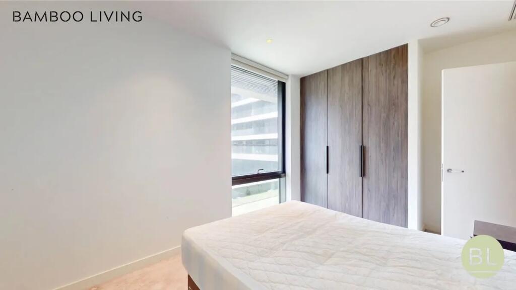 Bright double bedroom featuring a large window ...