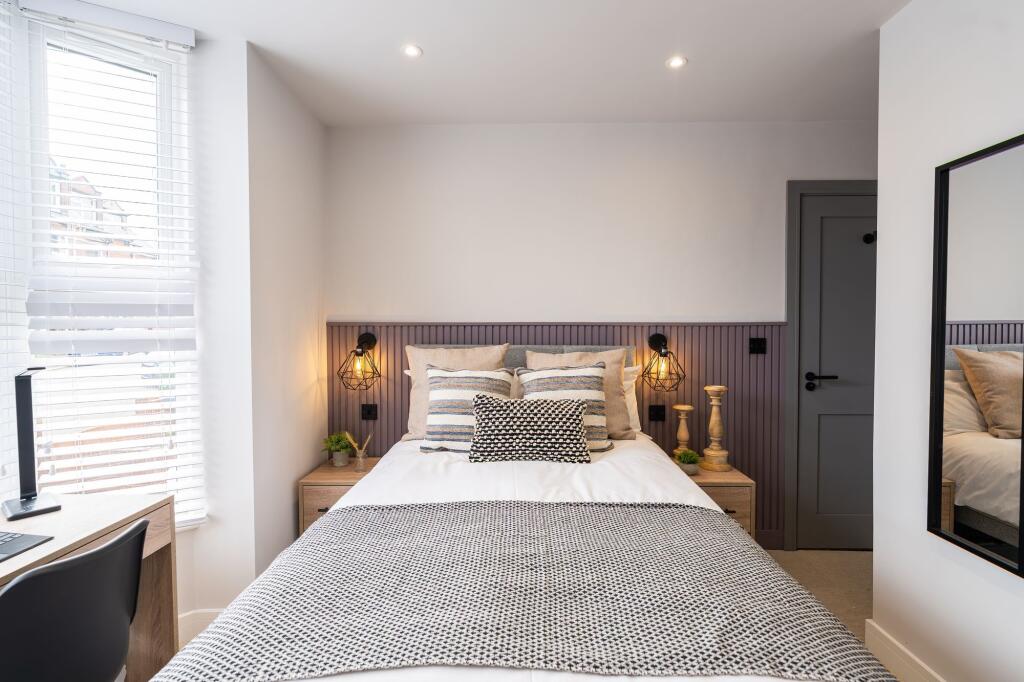 A stylish, well-lit master bedroom featuring a ...