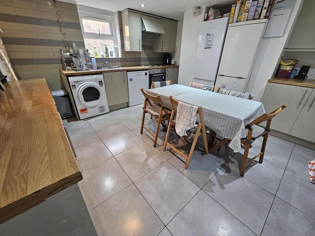 A bright, modern kitchen featuring a clean tile...