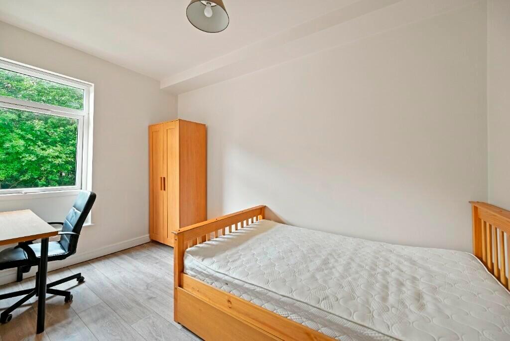 A bright and clean single bedroom featuring a w...