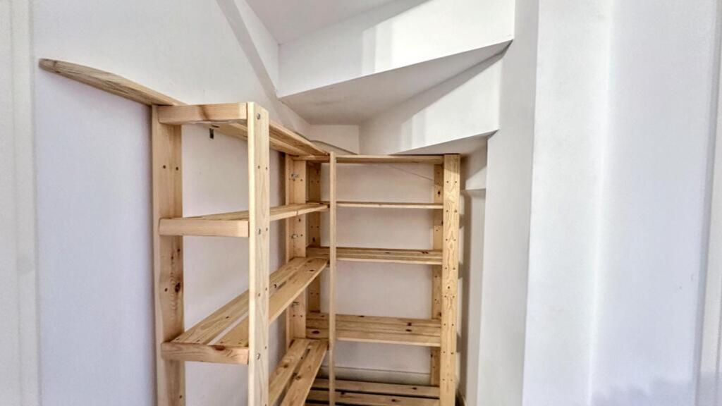 An organized storage area with wooden shelving,...