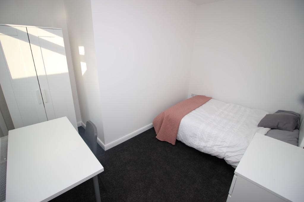 A bright and tidy single bedroom featuring a co...