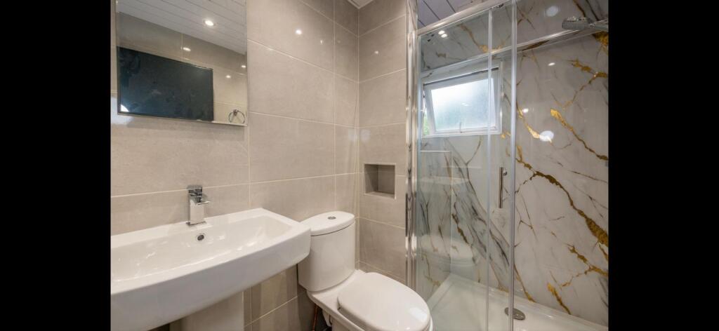 Contemporary bathroom with a wall-mounted sink,...