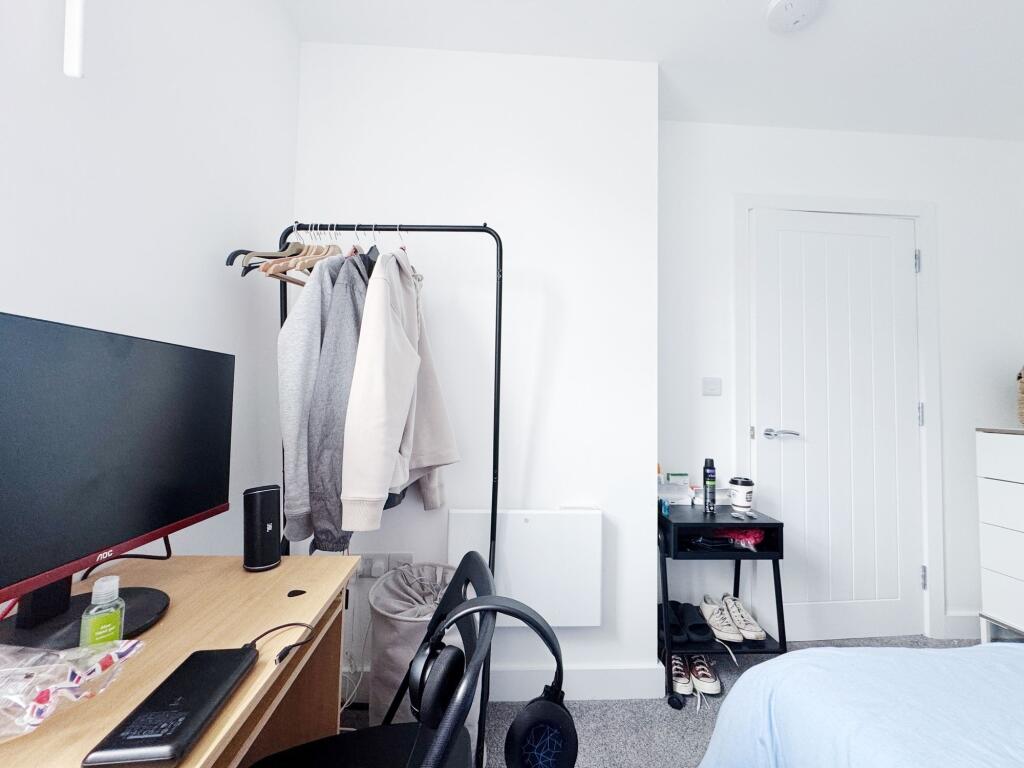 Bright, tidy bedroom with neutral décor featuri...