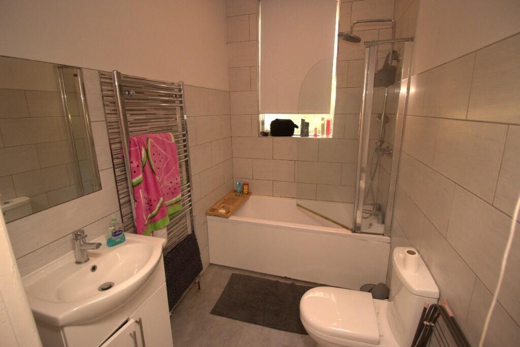 A clean, modern bathroom featuring a full bath ...