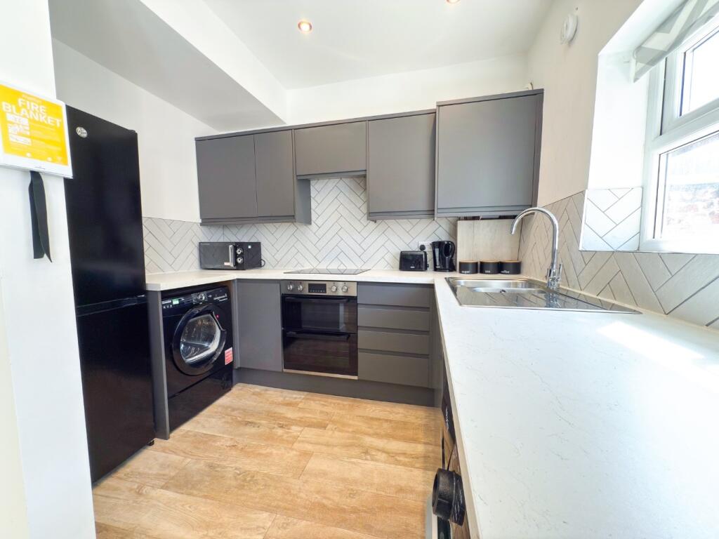Bright modern kitchen with sleek grey cabinets,...