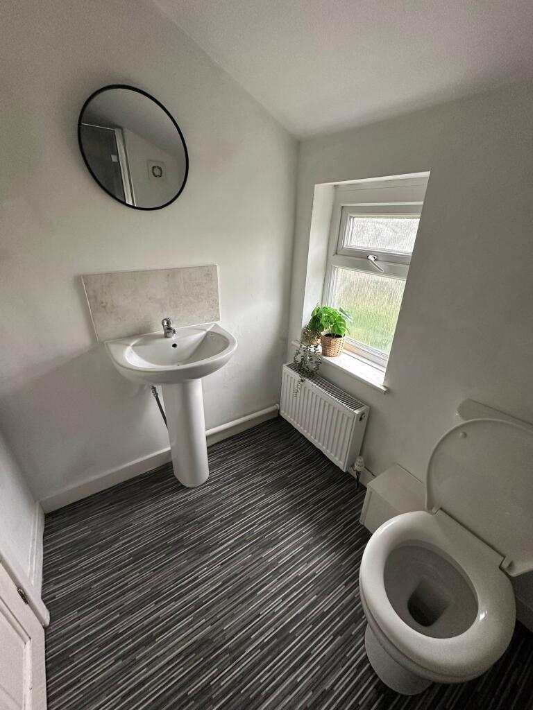 Bright and clean bathroom featuring a white ped...