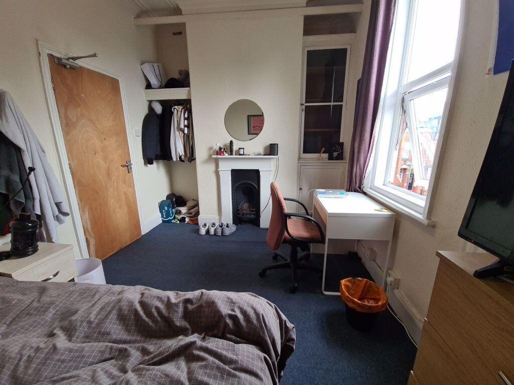 A cozy bedroom featuring a bed, a window provid...