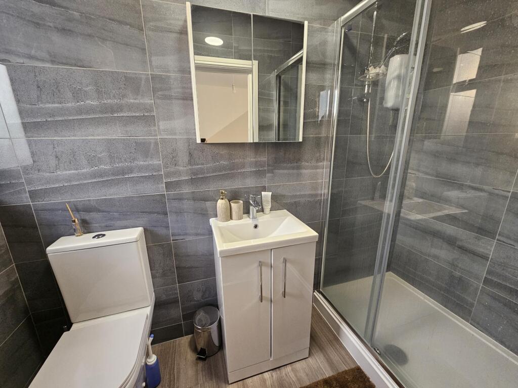 Modern bathroom featuring a sleek glass shower ...