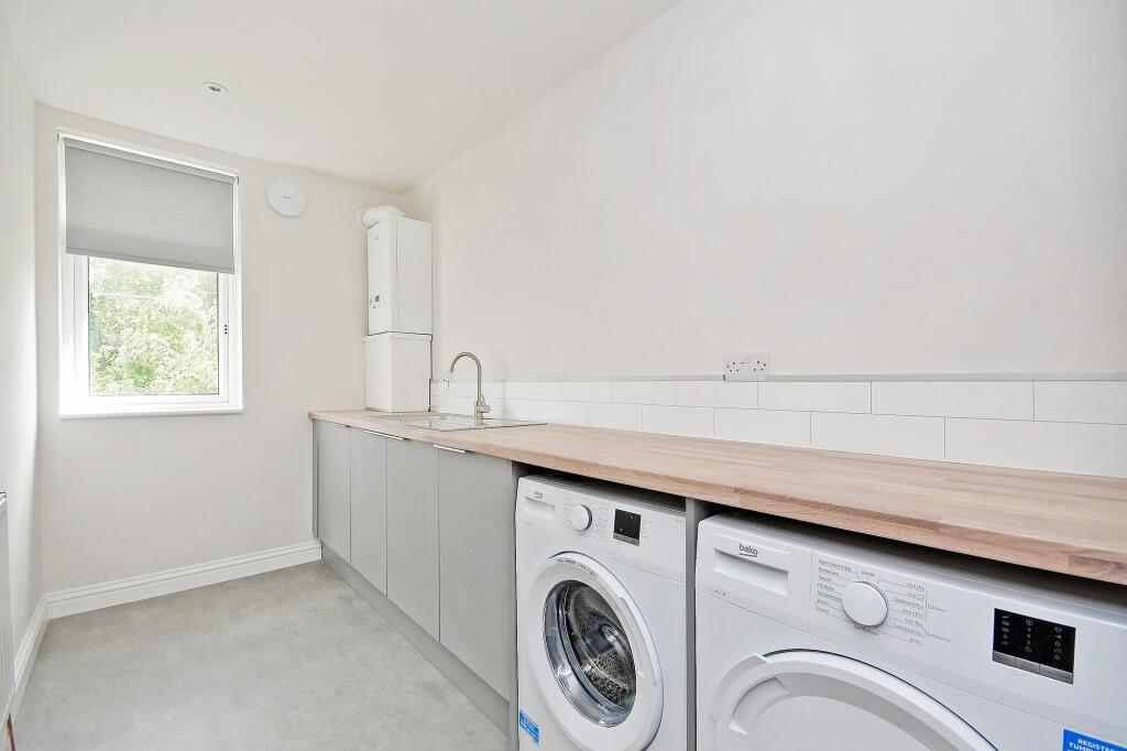A modern, minimalist kitchen with ample counter...