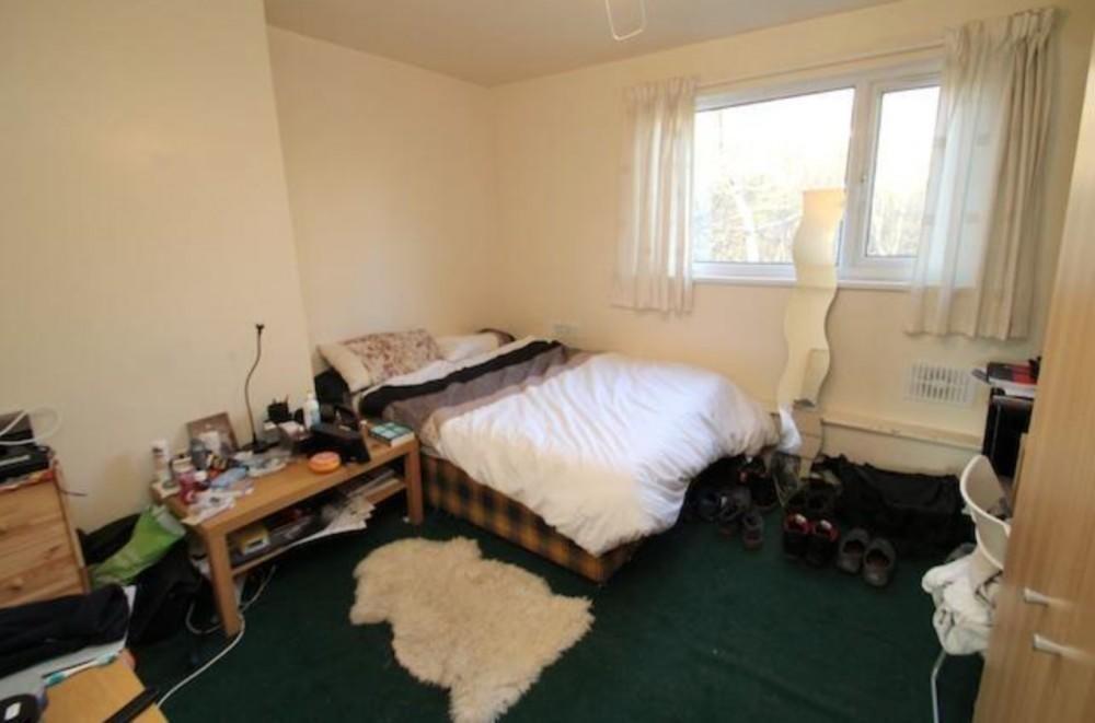 Cozy double bedroom featuring a large window th...