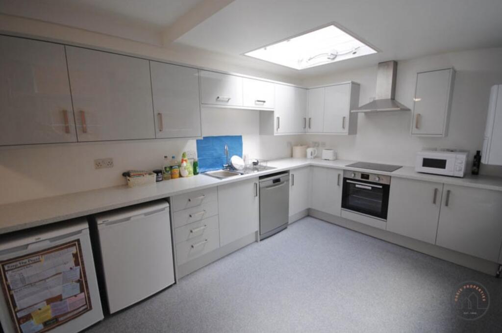 A bright and modern kitchen with clean white ca...