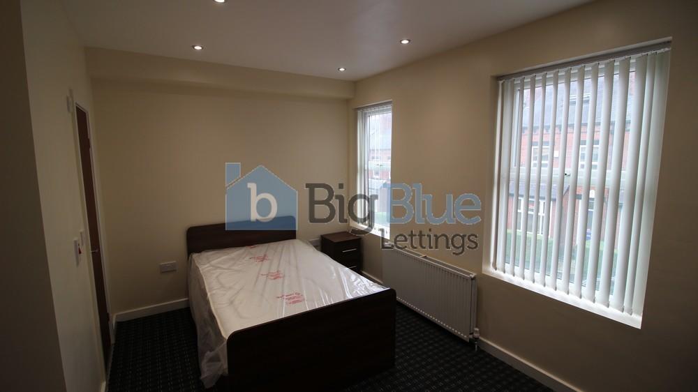 A simple and neat single bedroom featuring a wo...