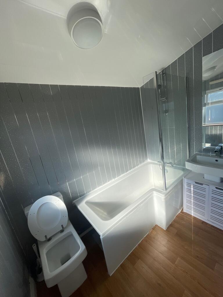 Bright and modern bathroom suite featuring a wh...